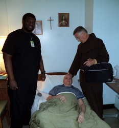 Fr. Simeon is comforted by Br. Norbert and his caregiver