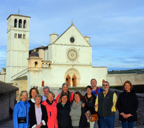 Pilgrims stand in front of the Basilica of Saint Francis in Assisi, Italy