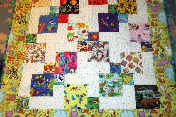 Jeanne hand-made this quilt for her niece's son. The design is called “Eye Spy” . . . it’s meant for the parents and baby to play the “I spy with my little eye” game, so it has many juvenile fabrics in it with lots of colorful pictures. 