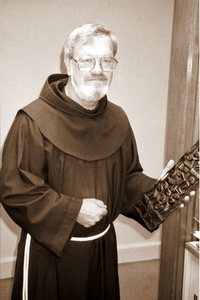 Fr. Gil Wohler, OFM, in 1996 with carved wooden art from South Africa